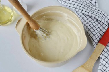 Hamuru çırpıcıyla iyice karıştır. Hamur çok kalın olursa, birkaç çorba kaşığı su ekleyin. Ama kalın krep hamuru sıvı olmamalı, yoksa krepler şişer ve düşer..