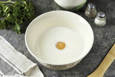 Süt, un ve 1-2 tavuk yumurtasını pürüzsüz olana kadar ayrı ayrı çırpın..