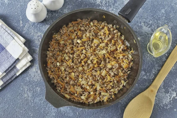 Kıyma parçalarını bir spatulayla kırmak, tam pişene kadar orta sıcaklıkta kızartmak..