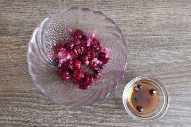 Haşlanmış domuz eti için kaplama hazırlayın. Bir kasede, kızılcıkları ardıç çileğiyle ez, doğranmış sarımsak ekle. Karıştır. Ayrı ayrı, sebze yağıyla acı biberi karıştır..