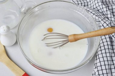 Büyük bir kasede, yumurtaları süt, tuz ve şekerle birleştirin..
