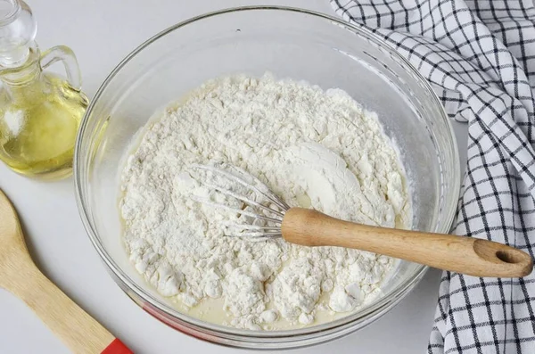 Ekli un ve kabartma tozu ekleyin. Hamuru pürüzsüz ve yumru olmadan çırpmak için iyice karıştırın..