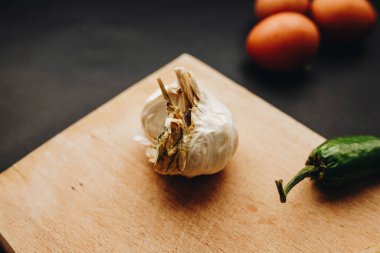 Tahtadaki sarımsağı kapat. Torbada yumurta ve biber.