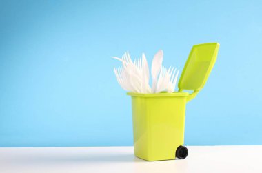 Çöp kutusunda plastik tek kullanımlık çatal ve kaşıklar.