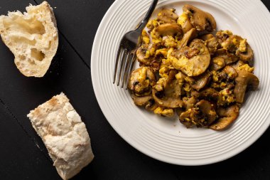 Kızarmış yumurta, mantar ve ekmek masada.