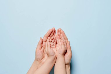 Anne ve bebek arka planda el ele tutuşuyorlar.