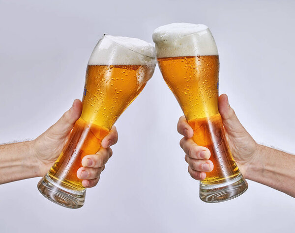 рука держа стакан пива, изолированные на белом фоне