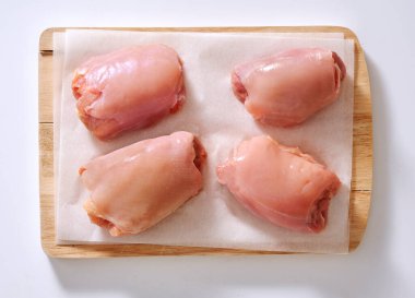 Stüdyo ortamında çiğ tavuk, kesme tahtasında.