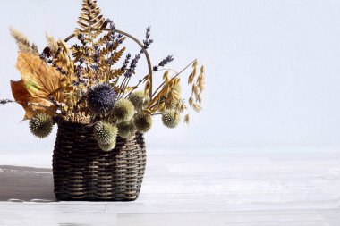 Kurumuş çiçek buketi ve bitkiler sepetin içinde gri bir arka plan, yan görüş, metin için yer