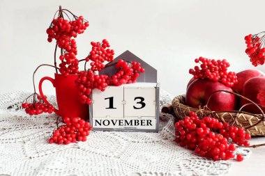 13 Kasım takvimi: İngilizce ayın adı, 13 numara, bir buket viburnum ve viburnum dalları, gri bir açık peçetedeki elmalar, gri arkaplan