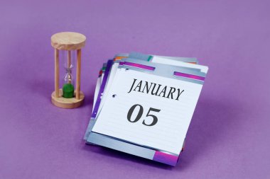 Calendar for January 5: loose-leaf calendar with the name of the month in English, numbers 05, hourglass on a pastel background