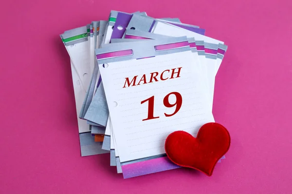 3月19日日历 桌子日历 上面写着3月份的英文名字 第19号 红心贴在粉刷的背景上 顶部视图 — 图库照片