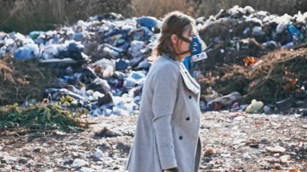 在垃圾堆中穿过烂泥的防毒面具中的一群年轻人. — 图库视频影像