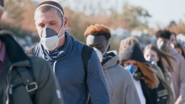 Primer plano de los jóvenes en máscaras de gas pasando por el desastre en un basurero. — Vídeos de Stock