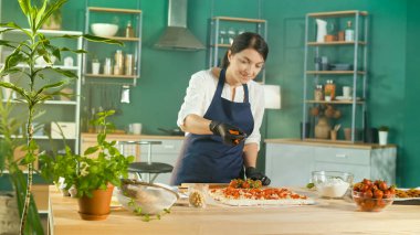 Pasta şefi kremalı, fındıklı ve çilekli pasta hazırlıyor.