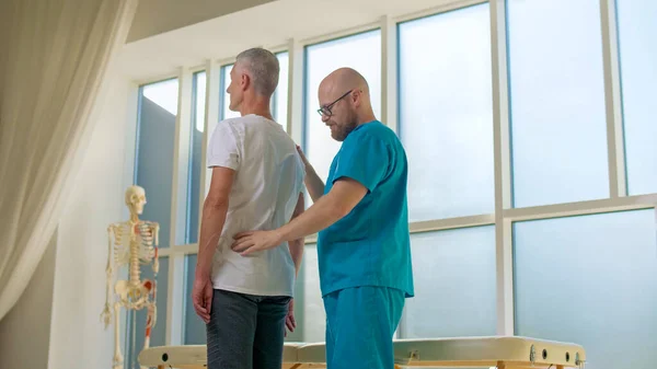Der Arzt sammelt eine vollständige Krankengeschichte von Rückenproblemen und führt eine detaillierte körperliche Untersuchung durch. Physiotherapie verbessert die Lebensqualität der Patienten. — Stockfoto
