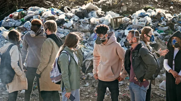 Gaz Maskeleri 'ndeki Genç Gönüllüler Çöp Döküntüsü' nde dururken Çevreye Bakım Yapıyor. Eylemciler Dünya Çapındaki Kirlilik Sorununu Tartışıyor.