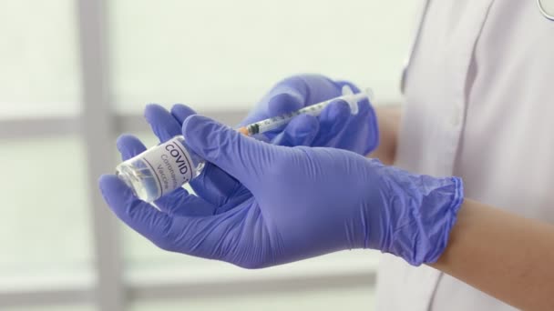 Close-up Un frasco de la vacuna contra el Coronavirus COVID-19 está siendo utilizado por un científico — Vídeo de stock