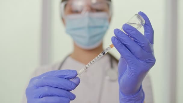 De arts vult de spuit met het vaccin ter voorbereiding van de injectie — Stockvideo