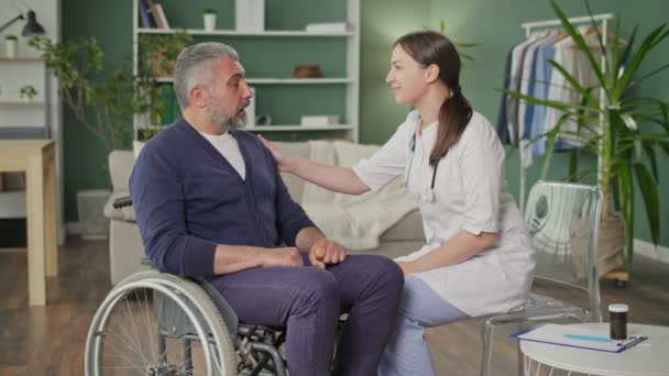 Homem Meia Idade Numa Cadeira Rodas Falar Com Uma Enfermeira — Vídeo de Stock