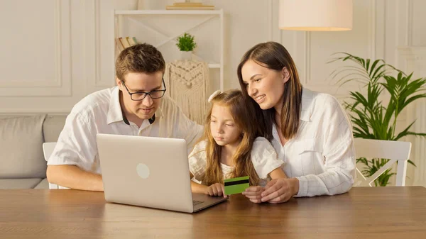 Szczęśliwa rodzina używa laptopa do zakupów online, Siedząc w domu. — Zdjęcie stockowe