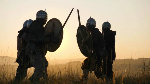 Savaşçı Viking siluetleri kılıç ve kalkanlar ile mücadele ediyoruz. Contre-jour