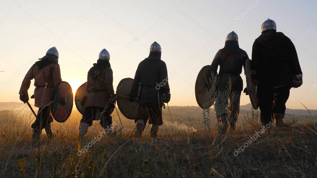 Warriors vikings stand in field and look at beautiful sunset on the battle field