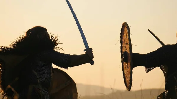 Siluety válečníků Viking bojují s meči a štíty. Contre-jour — Stock fotografie