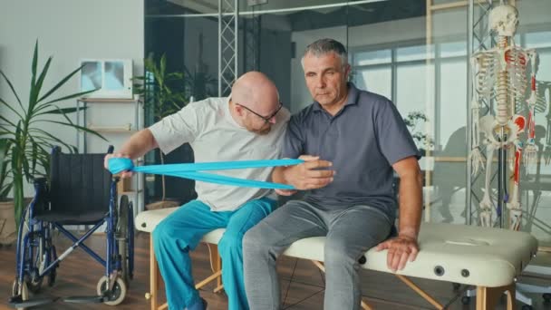 Um fisioterapeuta treina com segurança o paciente no uso de simuladores médicos — Vídeo de Stock