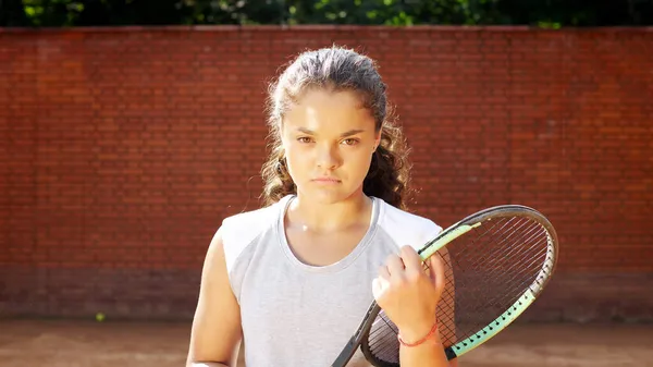 Retrato de una bonita joven jugadora de tenis con raqueta sonriendo y yendo a la cámara — Foto de Stock