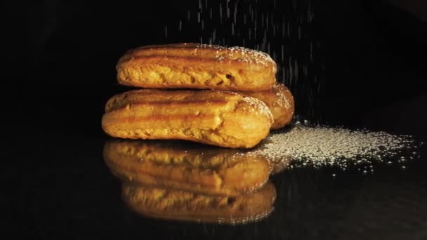 Dessert close-up on a black plate sprinkled with powdered sugar — Stock Video