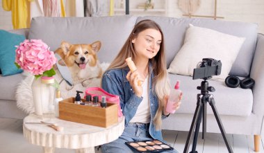 Çekici bir genç kız makyaj hakkında blog yazıyor. Genç bir kız güzellik video blogunu çekiyor. Genç bir kız kozmetik alanında uzaktan öğrenim görüyor.
