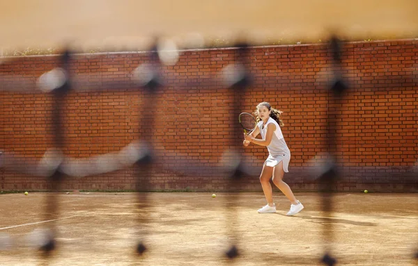 Chica joven bloqueando la pelota con la raqueta de tenis durante el entrenamiento —  Fotos de Stock