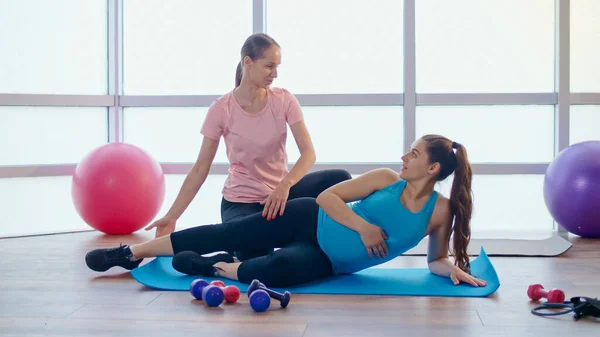 Mujer embarazada haciendo ejercicios para mujeres embarazadas con un entrenador personal —  Fotos de Stock