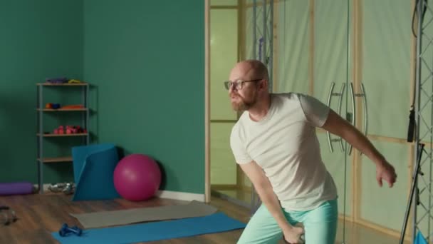 Hombre deportivo haciendo ejercicios con Kettlebells, fuerza de entrenamiento en el gimnasio. — Vídeos de Stock