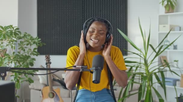 Un joven cantante africano profesional interpreta una nueva canción en un micrófono — Vídeos de Stock