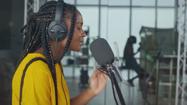 Молодой профессиональный африканский певец исполняет новую песню в микрофон — стоковое видео