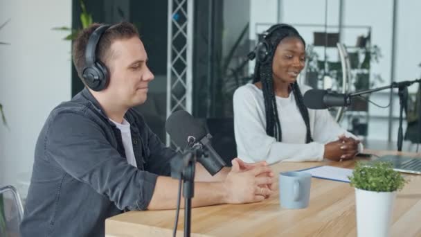 Confiada mujer afroamericana con el hombre blanco presentando en programa de radio — Vídeo de stock