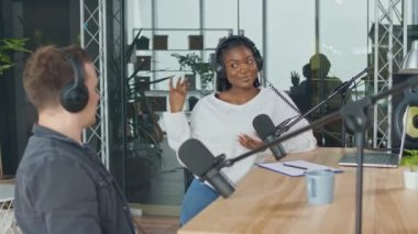 Bayan sunucu stüdyodaki Podcast Radyo İstasyonunda Konuk Bir Arkadaşla Konuşuyor.