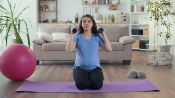 Happy Pregnant Woman entra a practicar deportes en casa en la sala de estar. — Vídeo de stock