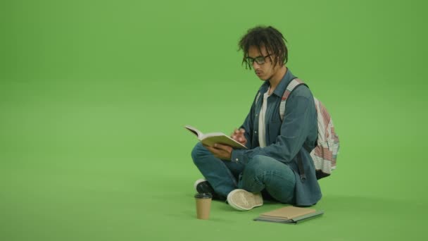 Homem Multicultural Jovem Óculos Camisa Denim Olhando Para Livro Vire — Vídeo de Stock