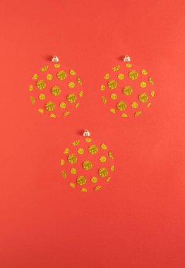 Kırmızı arka planda altın parıltısından yapılmış ağaç Noel süsü. Parlak yeni yıl partisi konsepti. Minimum düzlük.