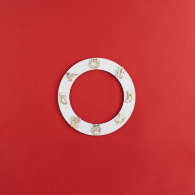 Yeni yıl beyazı halka dairesi ahşap süslemeler, ren geyiği, çorap çorap, hediye, süvari ve kırmızı arka planda zencefilli ekmek adam ile yatıyordu. Yaratıcı Noel asgari kopya alanı kavramı.