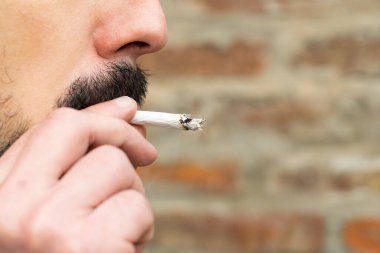 Yakından bakınca sigara içen bir adam görülüyor.