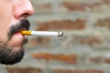 Yakından bakınca sigara içen bir adam görülüyor.