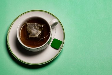 İçinde yeşil tonda fotokopi alanı olan bir fincan çay.