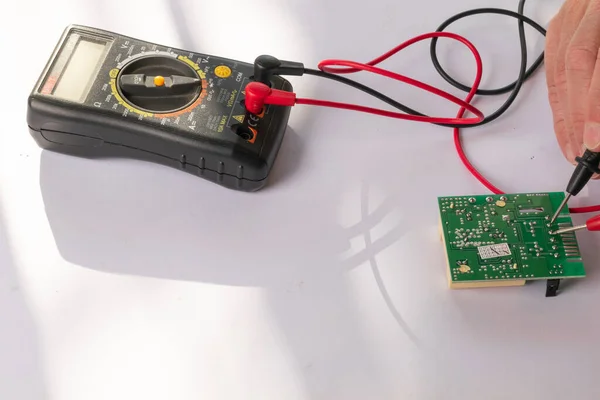 Multimeter with its tips in an electronic circuit