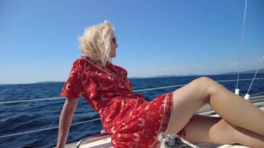 Yelkenliyle güneşlenen bayan.