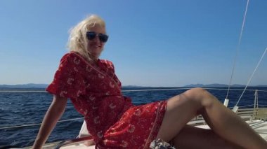 Yelkenliyle güneşlenen bayan.