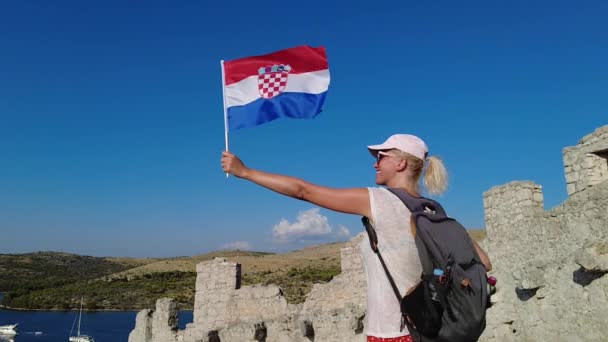 Kvinnan viftar med en kroatisk flagga på väggen i Ostrica — Stockvideo